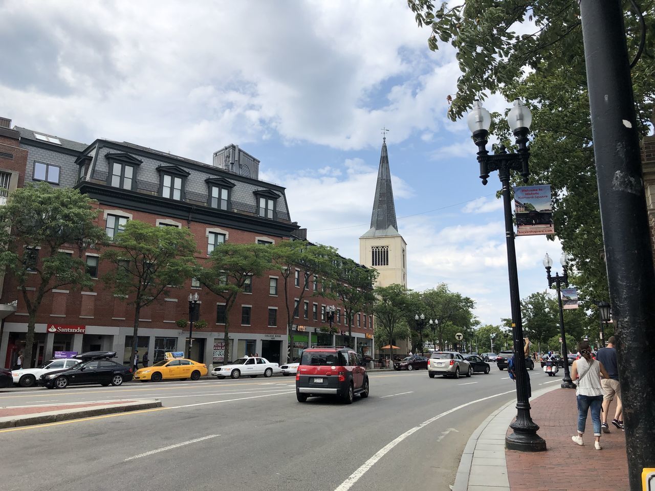 VEHICLES ON ROAD AMIDST BUILDINGS AGAINST SKY IN CITY