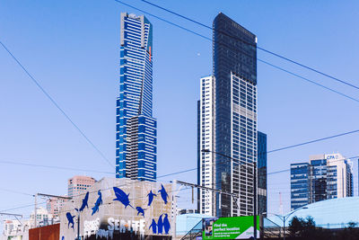 Low angle view of skyscrapers against blue sky