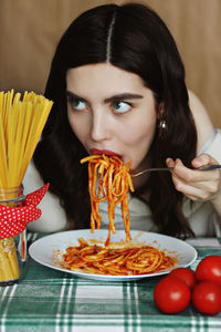 Woman eating pasta in restaurant