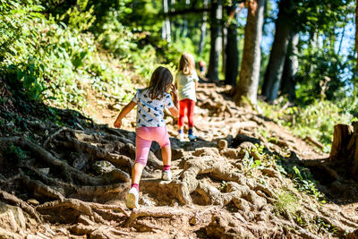 Full length of girls playing in forest