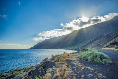 Scenic view of sea and mountains against sky