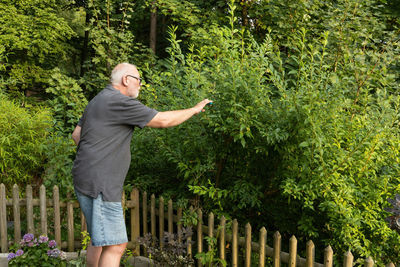 Rear view of woman standing against trees