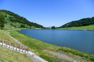 Scenic view of lake against clear blue sky