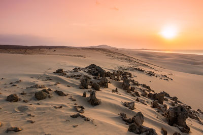 Scenic view of desert against sky during sunset