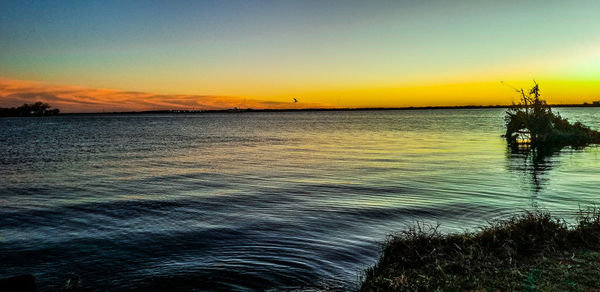 Scenic view of sea against romantic sky at sunset