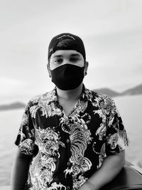 Portrait of young man standing against sea