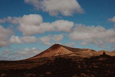 View of desert against cloudy sky