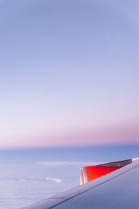 Cropped airplane flying over sea against clear sky