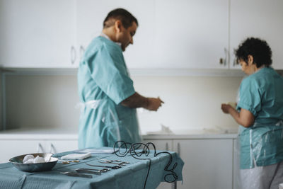 Male and female surgeons getting ready for surgery in hospital