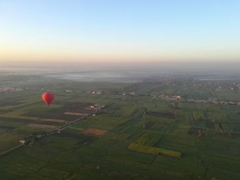 Scenic view of field against clear sky during sunset