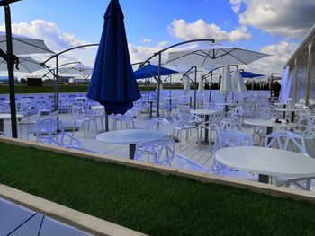 View of chairs on table by swimming pool