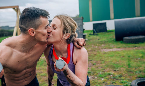 Sporty couple kissing while exercising on land