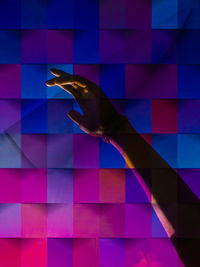 Digital composite image of hand on glass wall