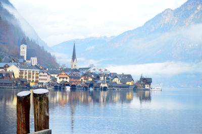 Buildings by lake against sky in city