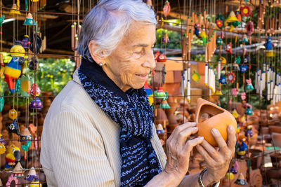 Senior woman holding souvenir at market stall
