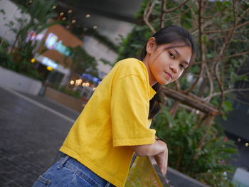 Portrait of young woman standing in city