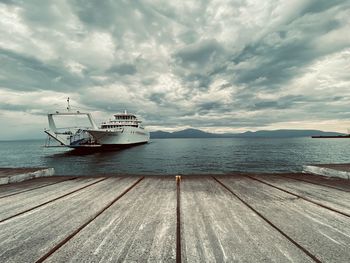 A ferry boat approaches the port in a moody day.