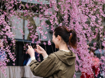 Woman holding flowers on tree