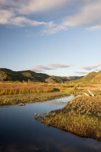 Scenic view of lake and mountains against sky