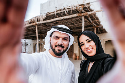 Portrait of smiling couple making hand sign