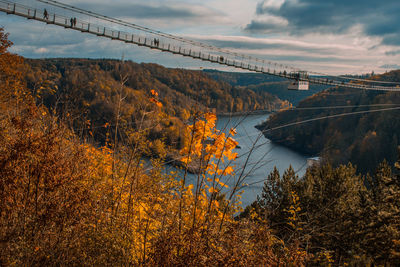 Bridge over river against sky during autumn