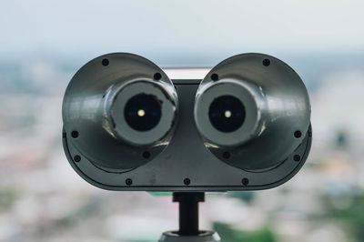 Close-up of coin-operated binoculars against sky