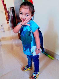 Portrait of smiling girl standing on tiled floor at home