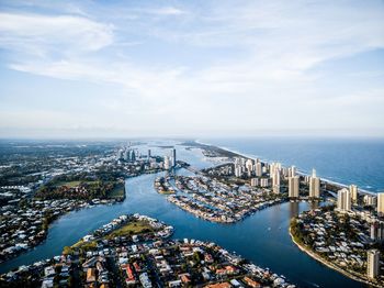 High angle view of cityscape by sea against sky
