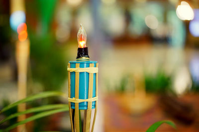 Close-up of illuminated candles on glass