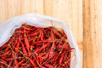High angle view of red chili pepper on wood