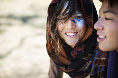 Smiling friends with face paint talking during traditional event