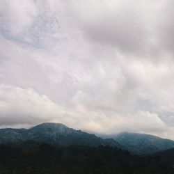 Scenic view of mountains against cloudy sky