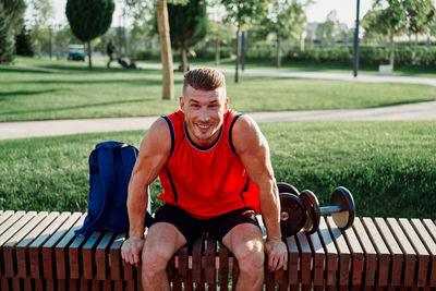 Portrait of young man sitting on bench