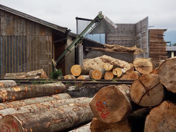 Stack of logs against building