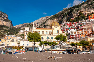 Houses in town by mountains against sky