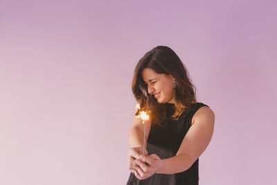 Young woman standing against gray background