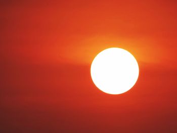 Low angle view of illuminated red light against sky during sunset