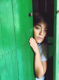 Boy peeking through green door