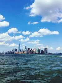 Sea by buildings against sky in city