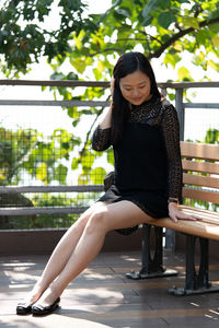 Portrait of young woman sitting on bench