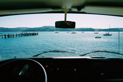 View of sea seen through car windshield