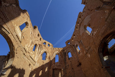 Low angle view of old ruins against blue sky