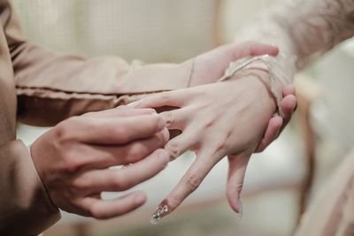 Midsection of couple holding hands