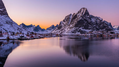 Scenic view of lake and mountains against sky during sunset