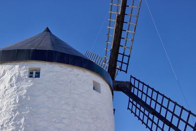 Low angle view of windmill against clear blue sky