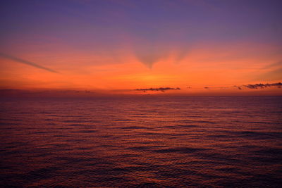 Scenic view of sea against dramatic sky during sunset