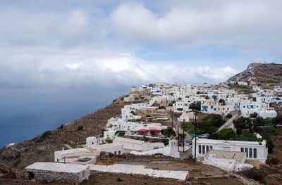 Buildings in city against cloudy sky