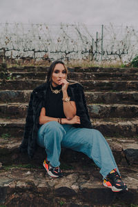 Portrait of young woman sitting on staircase