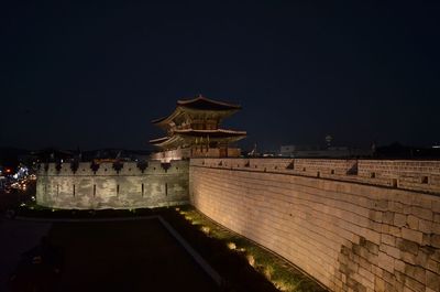 Illuminated building against clear sky at night