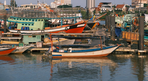 Fishing boats in harbor at city